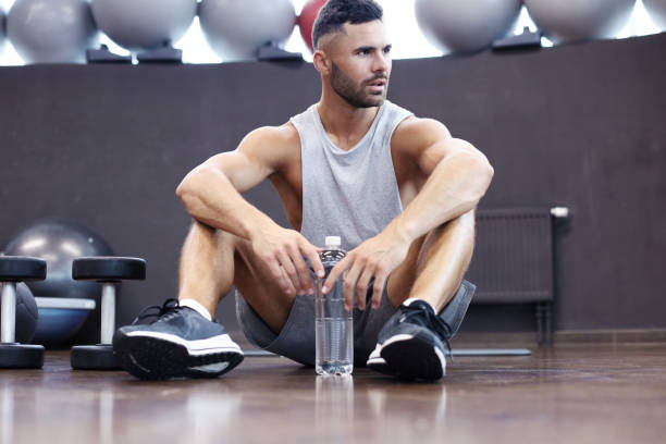 istock Sporty man resting, having break drinking water after doing exercise. 1160537721
