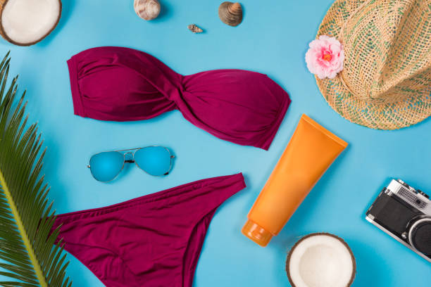istock Beach theme on the blue background. Sunglasses, hat, sunscreen, swimsuit, on the blue background. Top view. 1160542829
