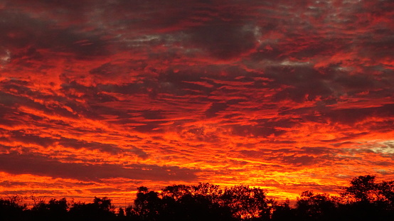 Horizontal caption dramatic sunset light clouds in golden hour, red , yellow and orange