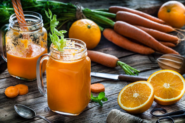istock Healthy drink: orange and carrot juice on rustic wooden table 1160547083