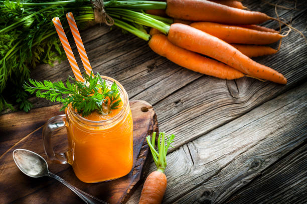 istock Healthy drink: carrot juice on rustic wooden table with copy space 1160548228