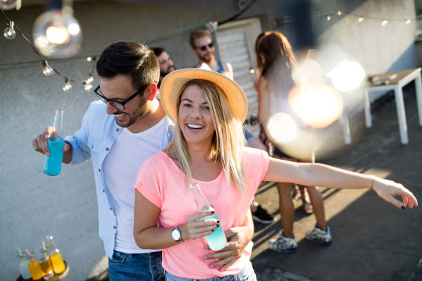 istock Young friends having fun at a rooftop party, playing the guitar, singing, dancing and drinking 1160548437