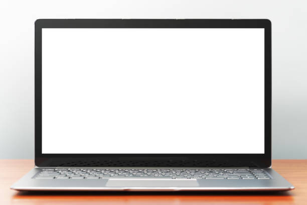 istock Laptop computer with white blank screen on wooden desk. 1160549084