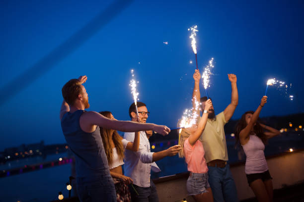 istock Friends enjoying a rooftop party and dancing with sparklers 1160549489