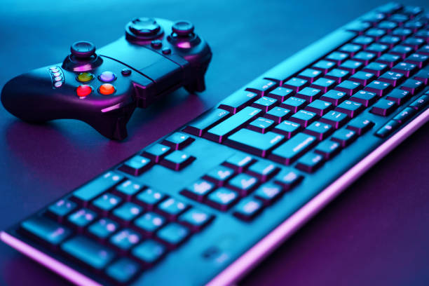 istock Keyboard and joystick on violet table background. 1160550885