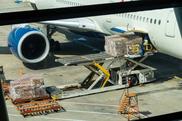 cena da bagagem e da carga do carregamento ao avião com operações de manipulação no aeroporto, conceito do curso e do transporte - airport equipment - fotografias e filmes do acervo