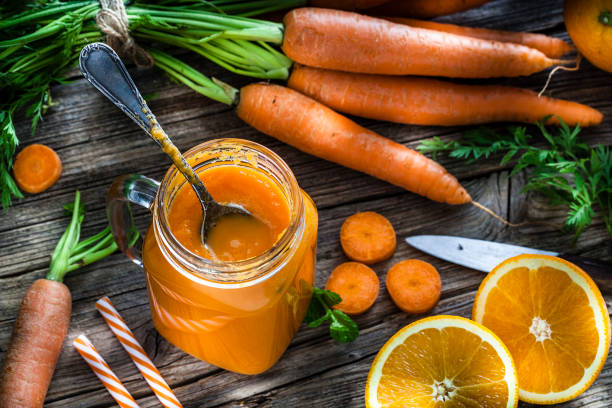 istock Healthy drink: orange and carrot juice on rustic wooden table 1160553419