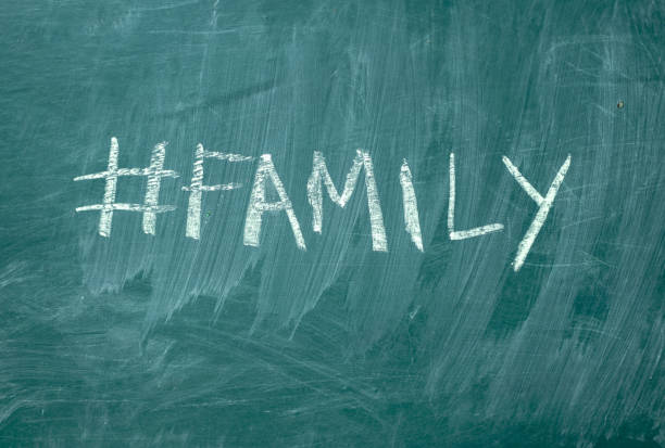 family hashtag it handwritten with white chalk on a green blackboard - single word love wood typescript imagens e fotografias de stock
