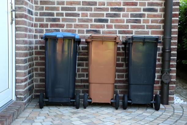 istock three different plastic carbage cans are standing at the house wall in a row 1160555425