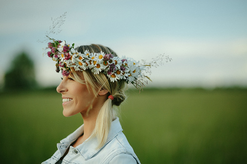 Beautiful young woman wearing flower wreath. Summer Solstice, Latvia.