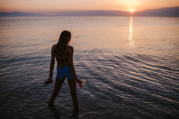 istock Young woman having fun in sea during beautiful sunset 1160557637