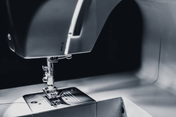 istock Modern compact electric sewing machine in the evening. View of needle and thread. Illumination from the built-in incandescent lamp. Sewing machine is used to stitch fabric and other materials together 1160557954