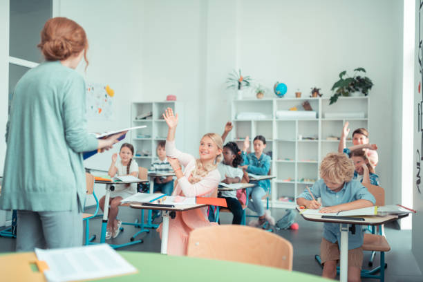 istock School children doing sums with their maths teacher. 1160558953