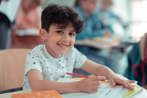 istock Pupil sitting at his desk and smiling. 1160558974