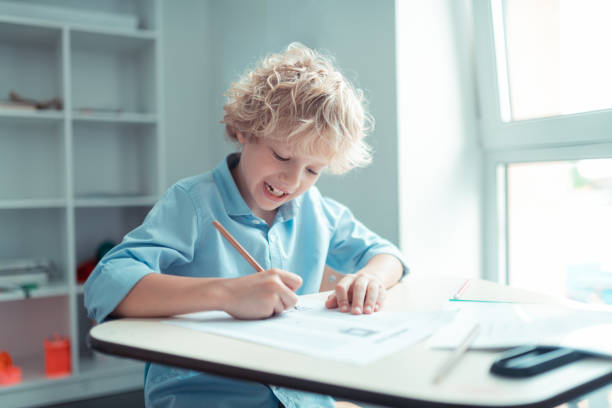 istock Cheerful pupil finishing his test in maths. 1160558997