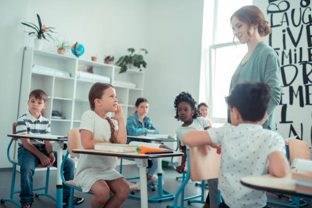 istock Little girl answering a question the teacher asked her. 1160559053