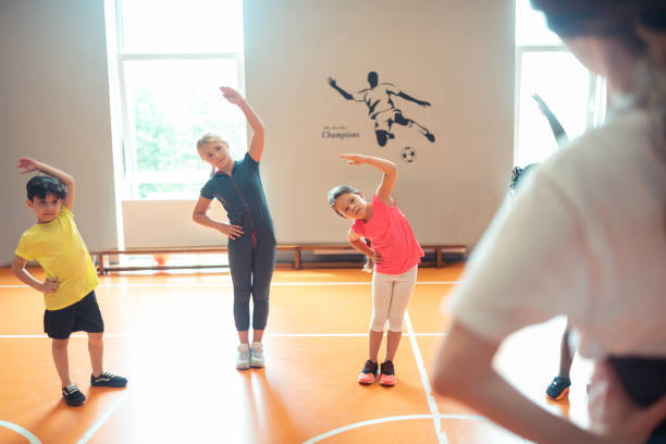 istock School children looking at their coach during training. 1160559225