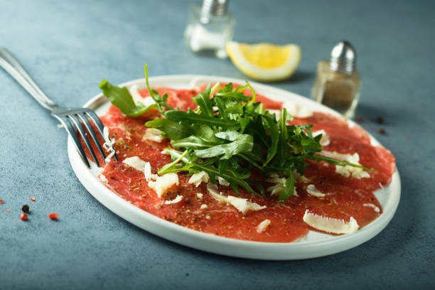 Beef carpaccio Homemade beef carpaccio with cheese and arugula carpaccio parmesan cheese beef raw stock pictures, royalty-free photos & images