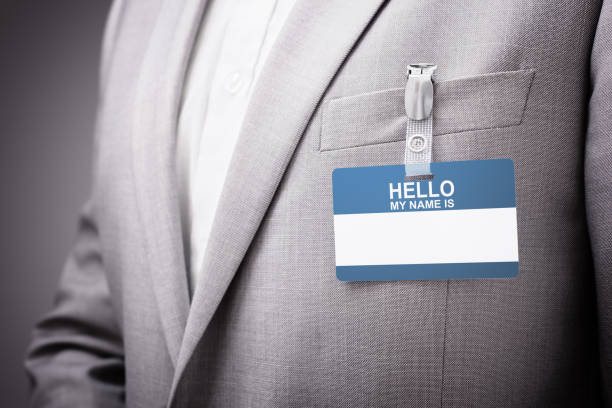 Businessman wearing Hello my name is tag Businessman at an exhibition or conference wearing a Hello my name is security identity name card or tag name tag stock pictures, royalty-free photos & images