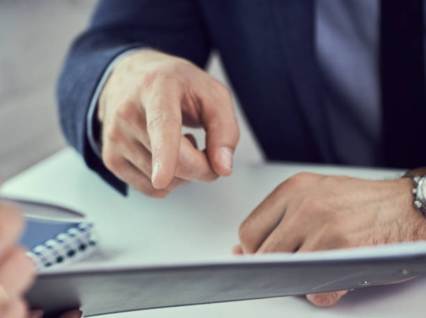 istock Two businessman are looking and studying statistics on tablet display close-up. Male hand opponent holds pen and points on tablet screen. 1160560446