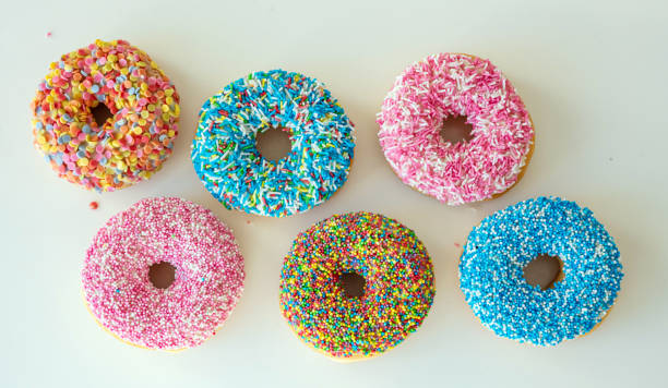 istock Doughnuts with colorful decoration on white color background. Top view 1160561303