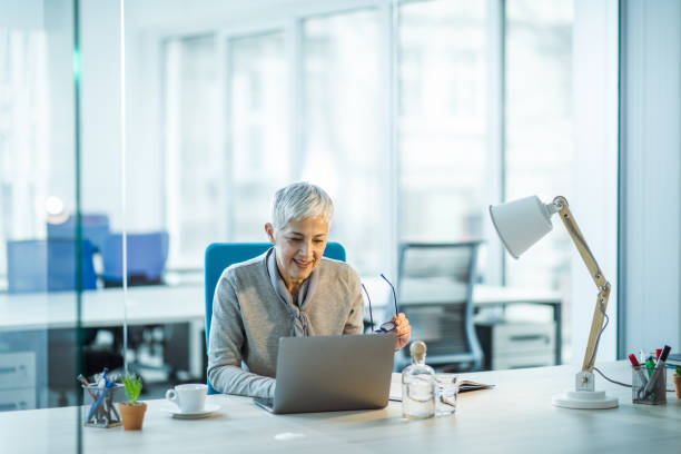 istock Happy senior entrepreneur working on laptop in the office. 1160561857