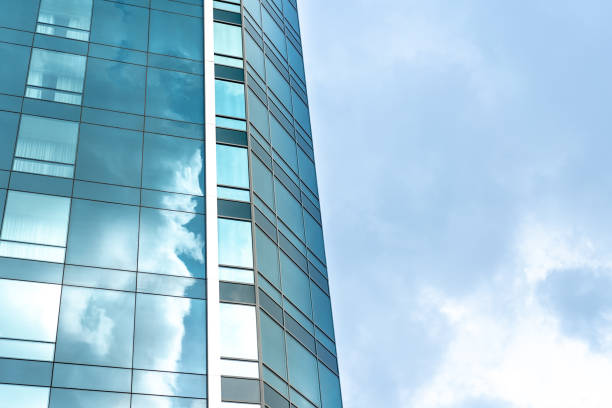 istock Perspective and underside angle view to textured background of modern glass building skyscrapers 1160562533