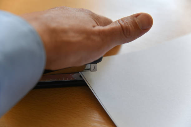 istock Hand staples paper on office desk 1160562545