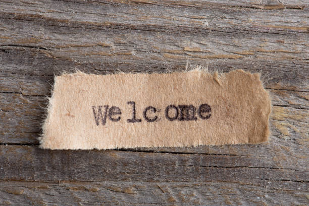 istock Welcome - word printed on typewriter, wooden background, vintage style 1160563616
