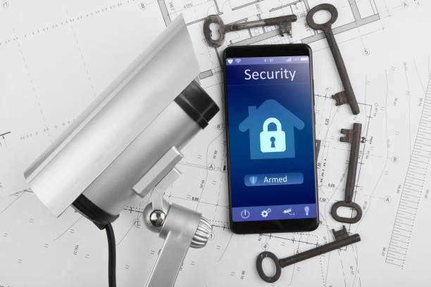 istock Home security concept smartphone with smart home app and surveillance cctv camera on the desk 1160563828