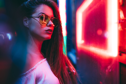 Young caucasian beautiful woman and neon light.