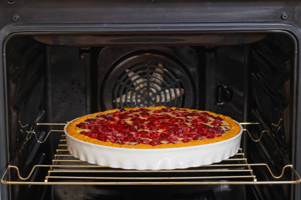 torta fatta in casa con lamponi rossi e neri preparati nel forno domestico. messa a fuoco superficiale. - dessert fruit torte red foto e immagini stock