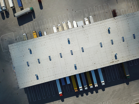Vista aérea del almacén de mercancías. Centro logístico en zona industrial de la ciudad desde arriba. Vista aérea de la carga de camiones en el centro logístico photo