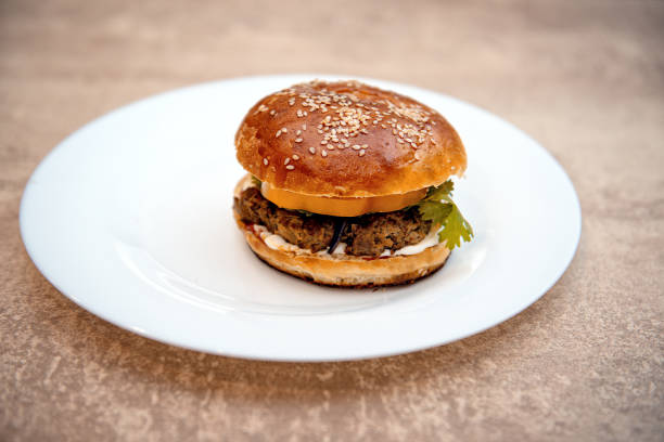 istock Homemade hamburger with fresh vegetables on white plate 1160564106