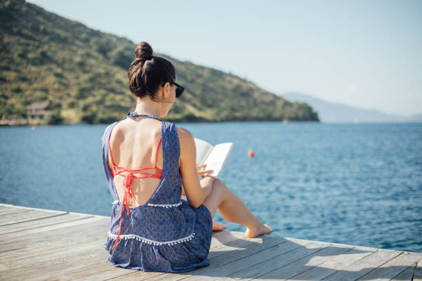 istock Woman reading a book on vacation 1160566321