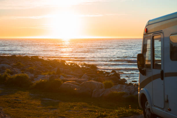 istock car at sunset by the sea, mountains. 1160569451