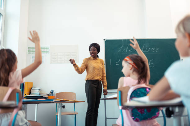 istock Dark-skinned teacher wearing bright blouse giving the lesson 1160569872