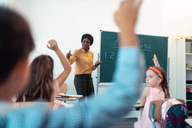 istock Dark-skinned teacher feeling satisfied with work of pupils 1160569890