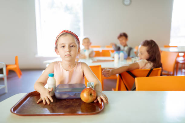 A mother prepares a healthy lunch for her children, she has orange Post-it notes on the kitchen counter