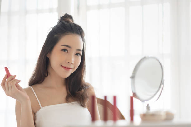 Happy woman applying makeup.