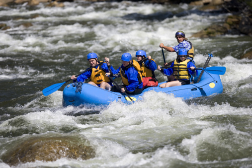 A group of men and women, with a guide, white water rafting on the Arkansas River, in Colorado.