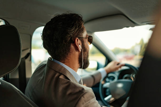 istock Businessman Using Headphones in the Car 1160573716