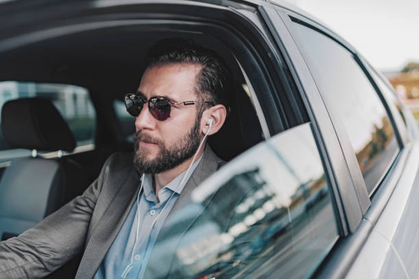 istock Businessman Using Headphones in the Car 1160573860