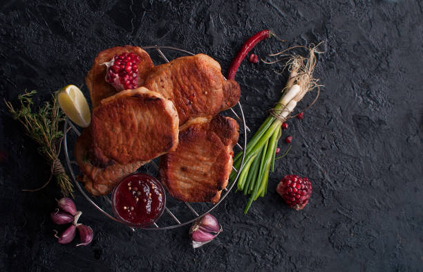 bifes da carne de porco do assado com sementes, vegetais e tome da romã em uma grade em uma tabela preta da ardósia. a vista do topo. copie o espaço. - sirloin steak top sirloin onion food state - fotografias e filmes do acervo