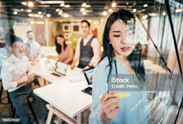 Asian Businesswoman Presenting Her Ideas For Company Development Stock Photo - Download Image Now