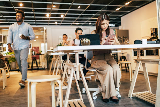 istock Young woman using digital tablet and smart phone in open co-working office 1160579497