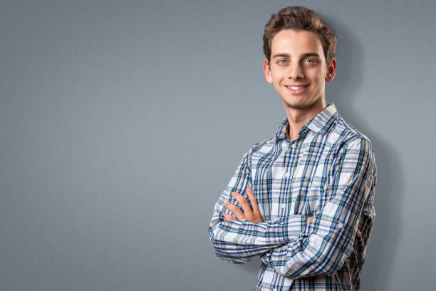 istock Handsome young man smiling with arms crossed 1160580308