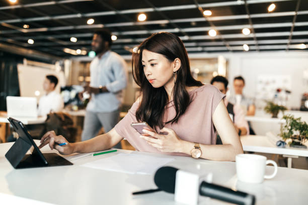 istock Young woman using digital tablet and smart phone in open co-working office 1160580332