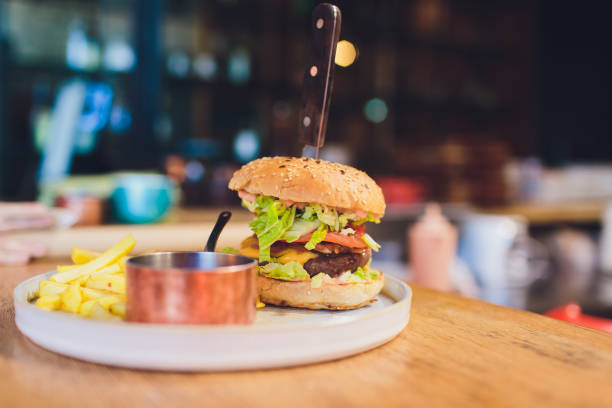 istock Prepare delicious fragrant golden sesame burger with fried egg spinach and meat cutlet placed on a table. 1160580797