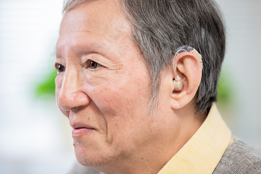 elder patient wear audiphone to improve his hearing